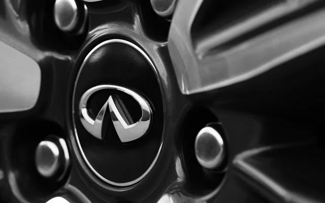 Close-up of a black and silver wheel rim with the INFINITI logo in the center.