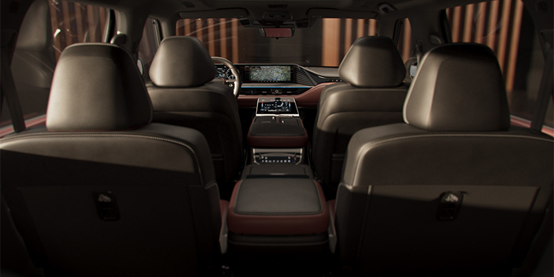 View of the inside of a 2025 INFINITI QX80 showing brown leather seats and a modern dashboard.